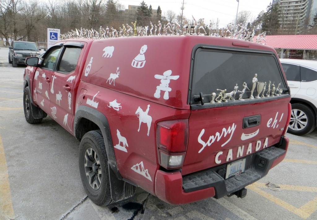 red truck with various trophy topping figures attached all over exterior